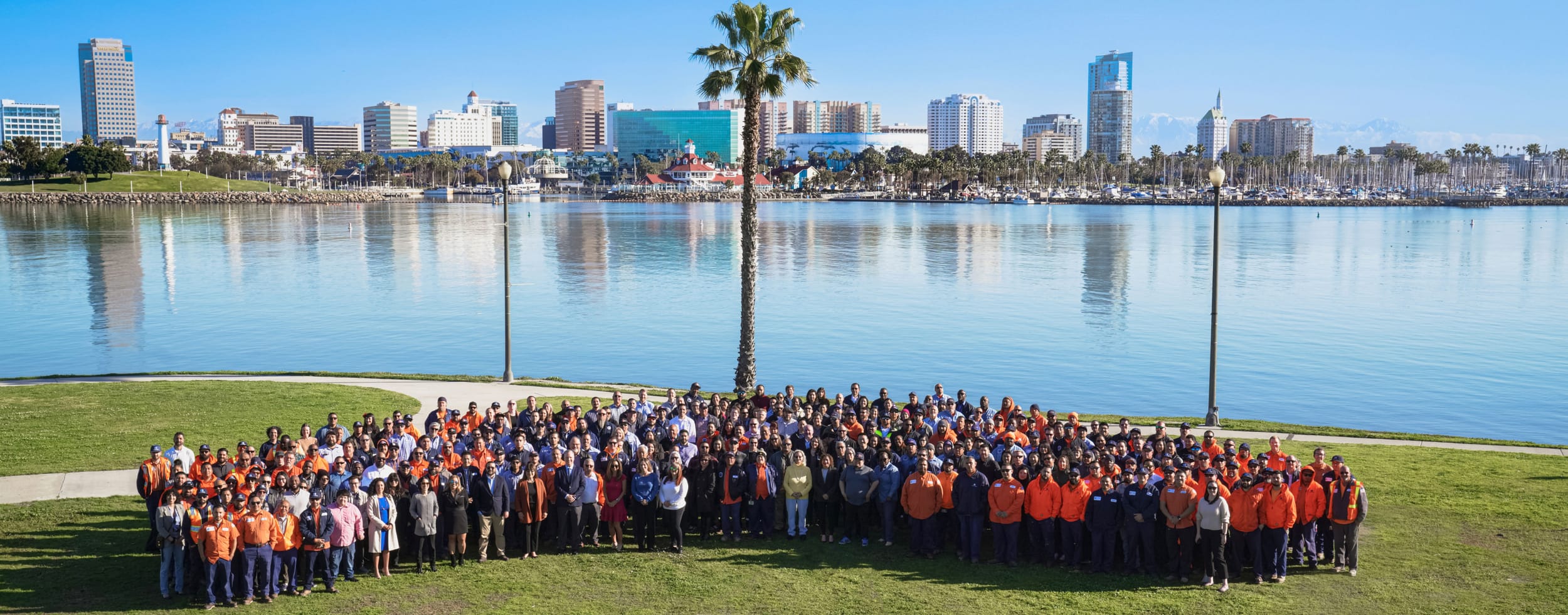 Long Beach Utilities employees gathered at lake with city in the background